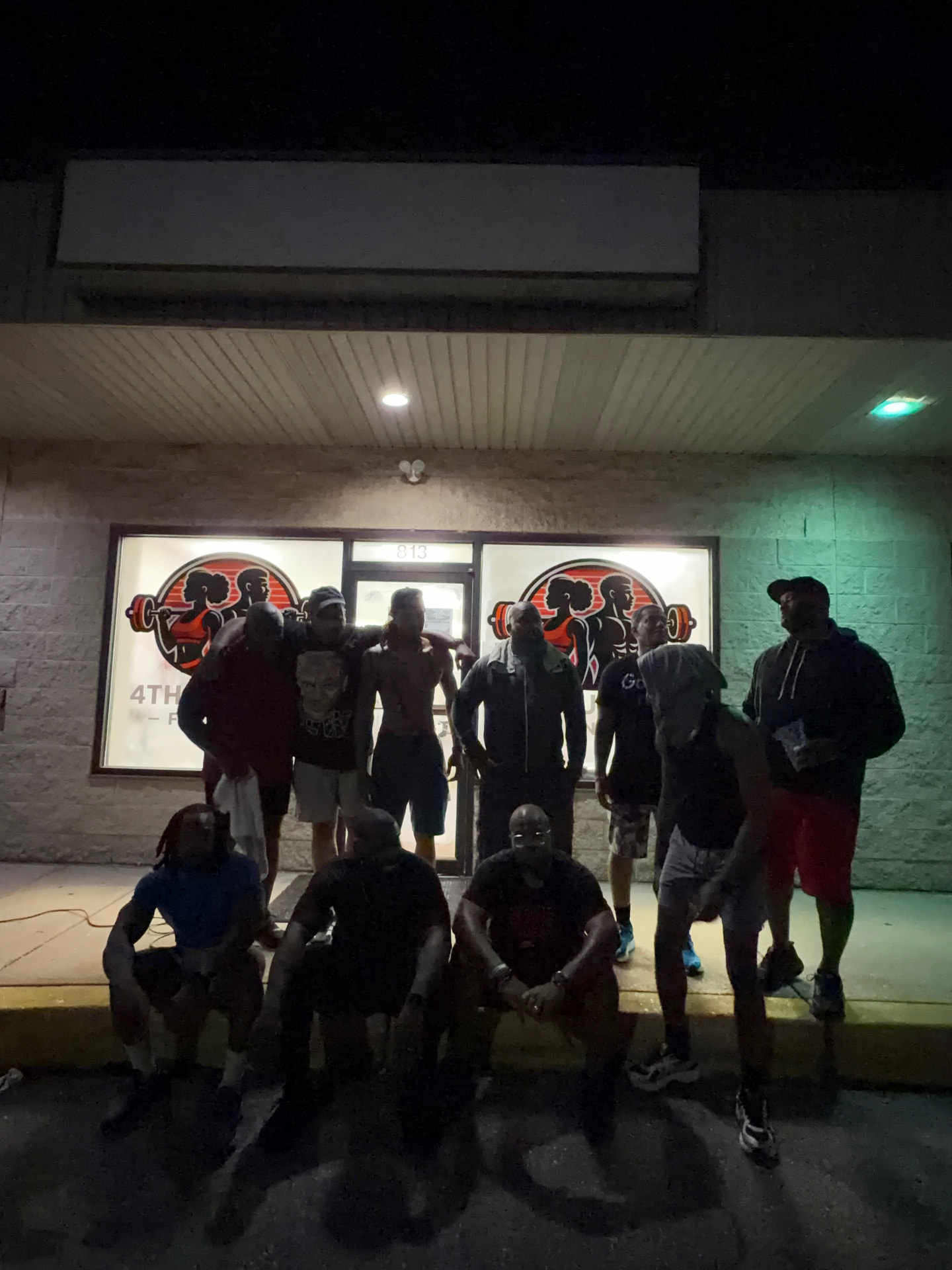 Members outside the 4th Quarter Fitness storefront at night